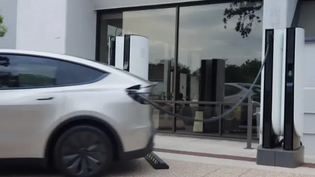 خودروی تسلا (Tesla) در حال حرکت از ایستگاه سوپرشارژر