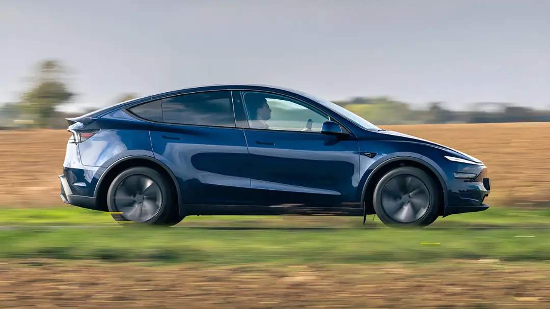 خودرو تسلا مدل Y (Tesla Model Y) آبی‌رنگ در حال حرکت در جاده