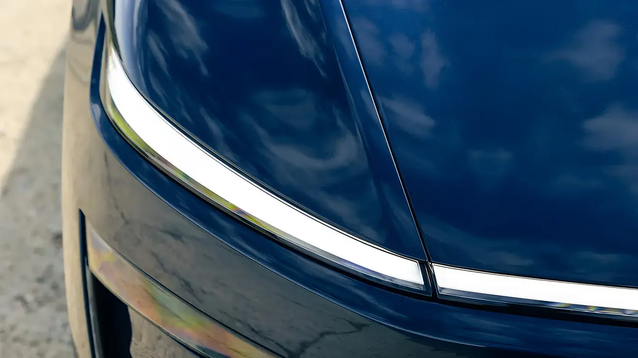 چراغ جلوی خودروی تسلا (Tesla Model Y) با بدنه آبی تیره