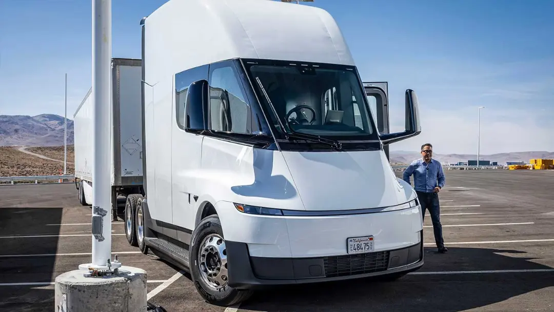 کامیون کشنده تسلا سِمی (Tesla Semi) سفید رنگ در کنار یک مرد در فضای باز