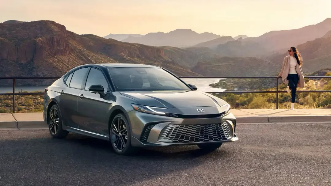 خودرو تویوتا کمری (Toyota Camry) خاکستری در جاده‌ای کوهستانی