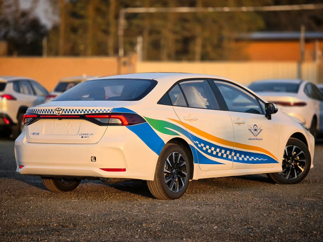 خودروی سفید تویوتا کرولا (Toyota Corolla) با طرح‌های رنگی آبی و سبز