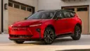خودرو قرمز رنگ تویوتا کراون سیگنیا (Toyota Crown Signia) مدل ۲۰۲۷ در مقابل یک ساختمان