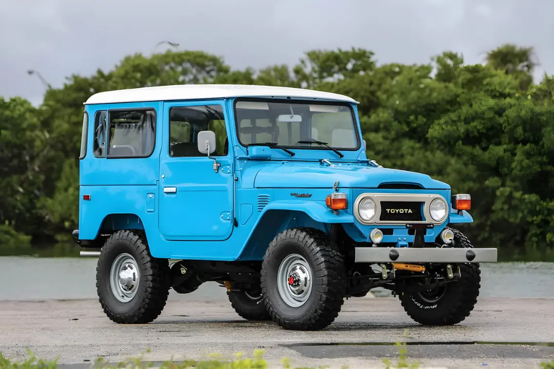 تویوتا لندکروزر (Toyota Land Cruiser) سری ۴۰ با بدنه آبی و سقف سفید در فضای باز