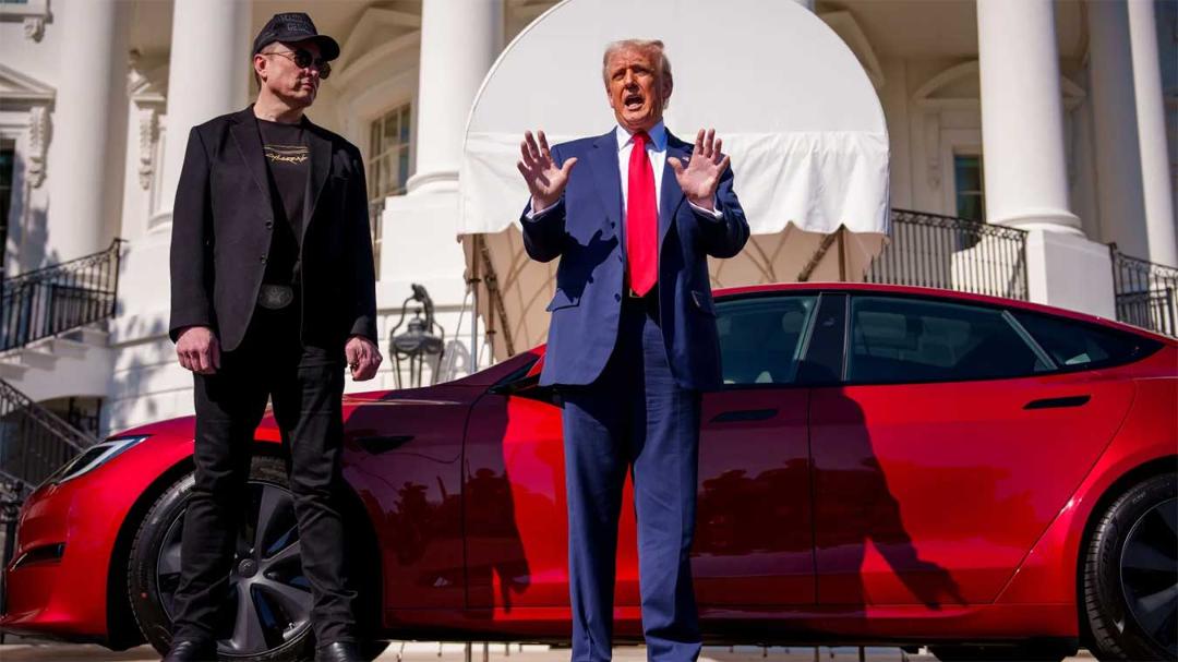 دونالد ترامپ (Donald Trump) در کنار یک خودروی قرمز تسلا (Tesla) در مقابل کاخ سفید