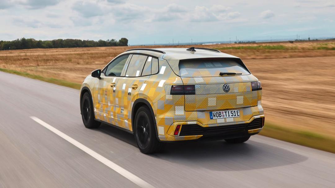 خودروی آزمایشی فولکس‌واگن (Volkswagen) با پوشش کدر زرد و سفید در حال حرکت