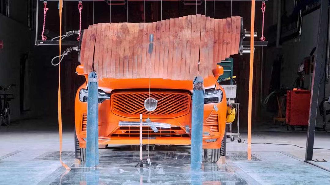 آدمک تست تصادف گوزن (Deer Test Dummy) در مقابل جلوی خودروی نارنجی ولوو (Volvo)