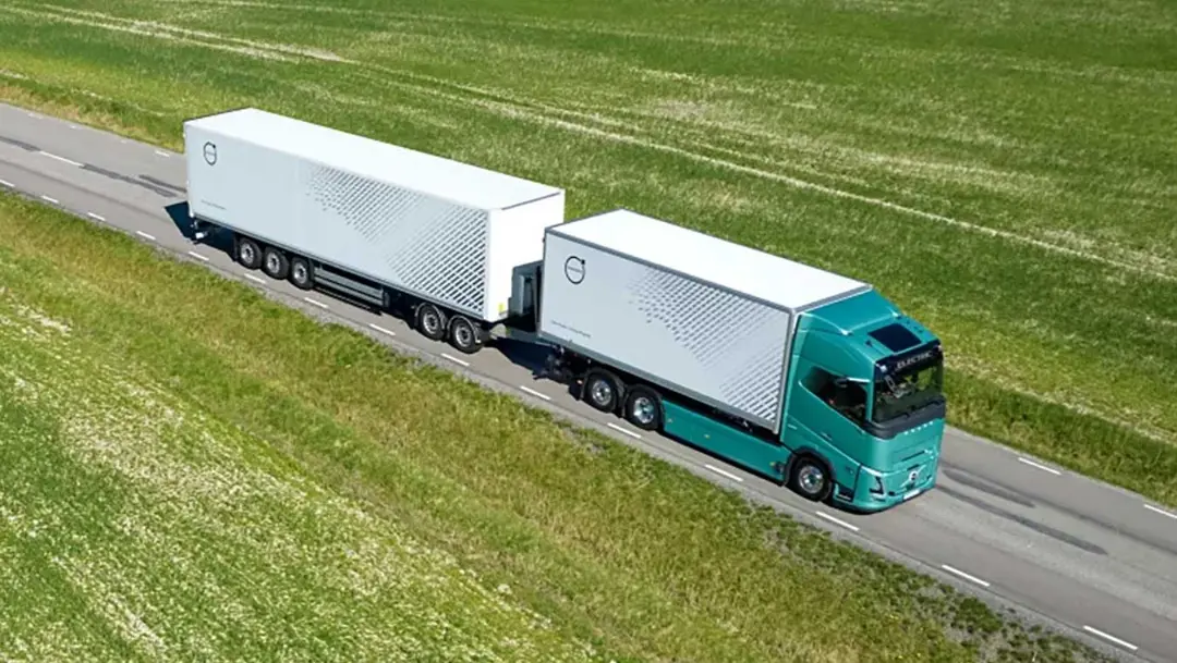 کامیون برقی ولوو (Volvo) با دو تریلر سفید در حال حرکت در جاده