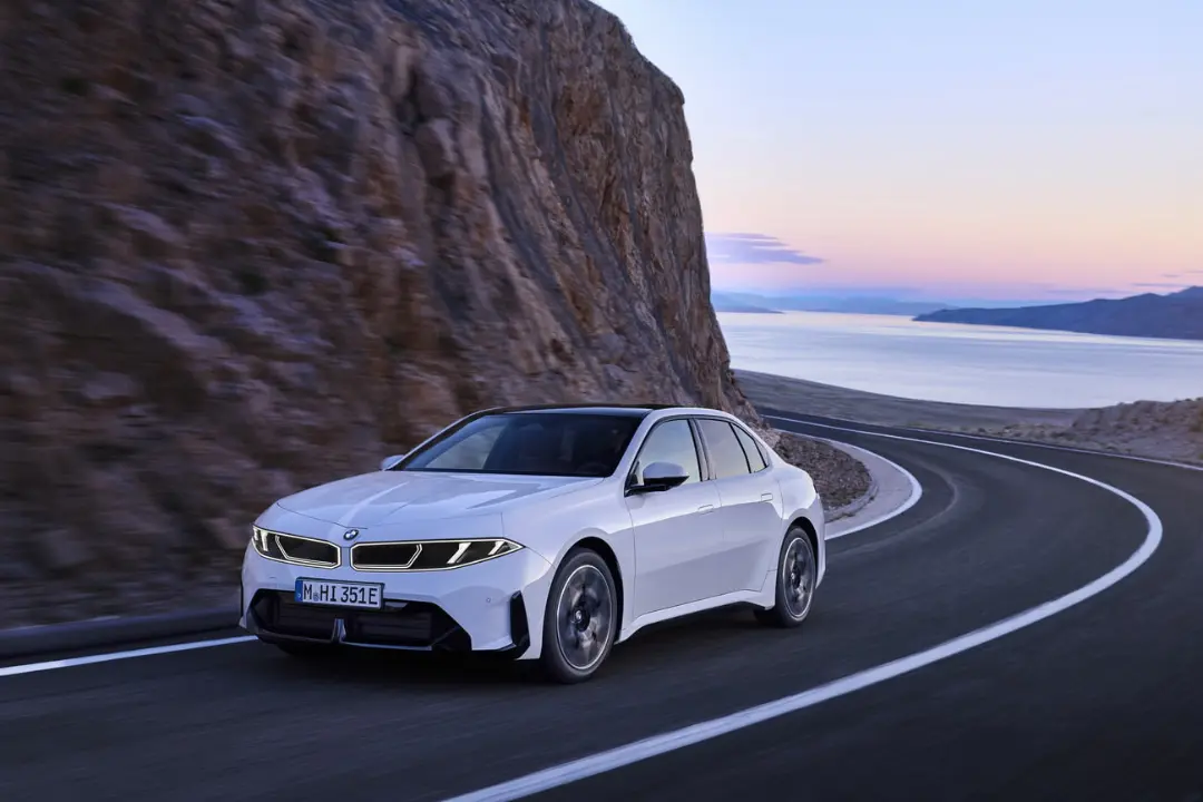 خودروی برقی سفید (BMW i3) در حال حرکت در جاده‌ای کوهستانی