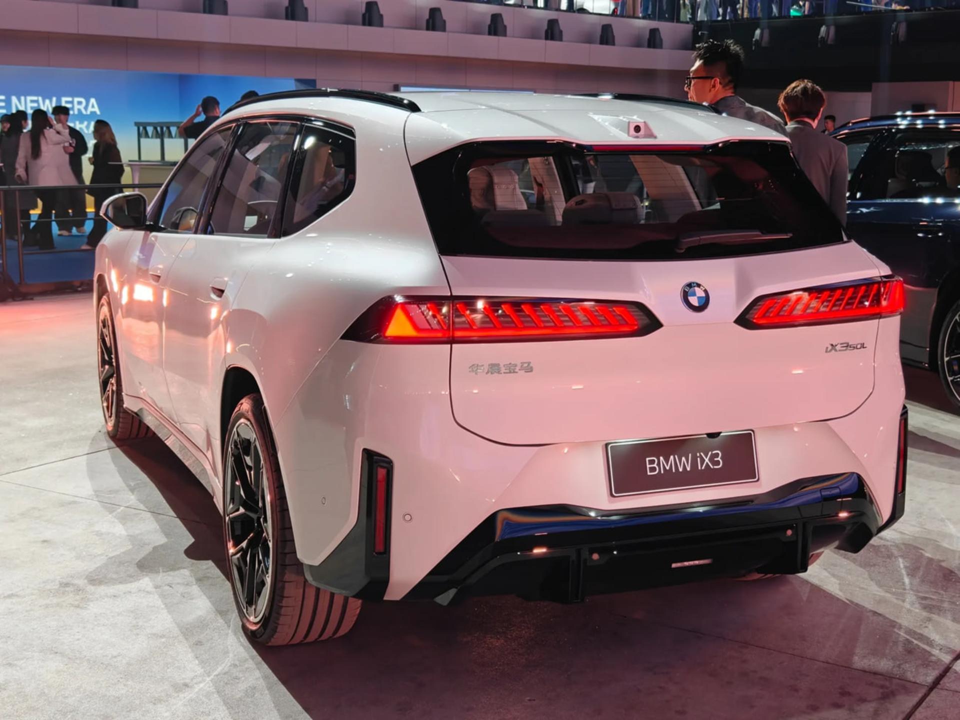 نمای پشت خودروی برقی سفید رنگ مدل BMW iX3 در نمایشگاه خودرو