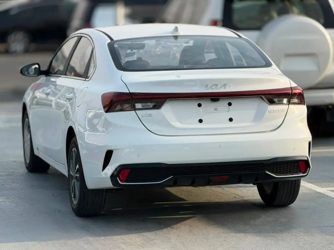 نمای عقب خودروی سفید کیا K3 (Kia K3) در فضای باز