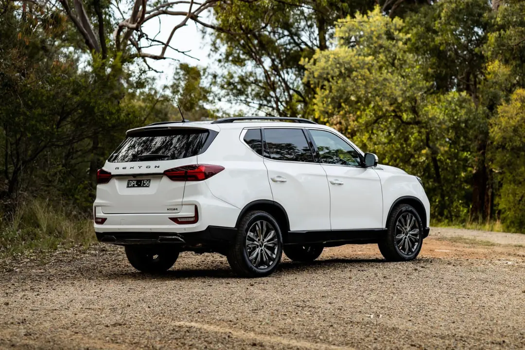 خودرو سفید رنگ رکستون (Rexton) مدل ۲۰۲۶ در جاده‌ای خاکی میان درختان