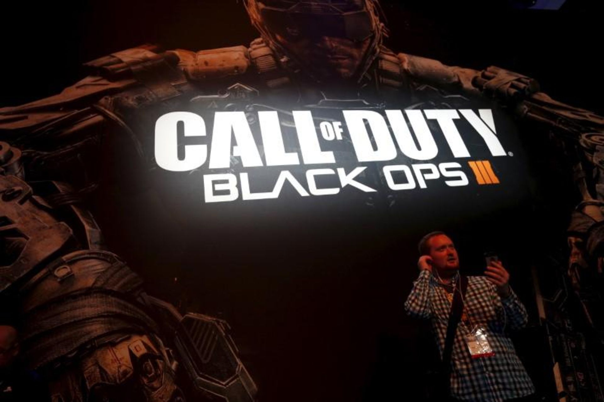 An attendee stands in front of the "Call of Duty Black Ops III" video game poster at the Sony PlayStation booth at the Electronic Entertainment Expo, or E3, in Los Angeles
