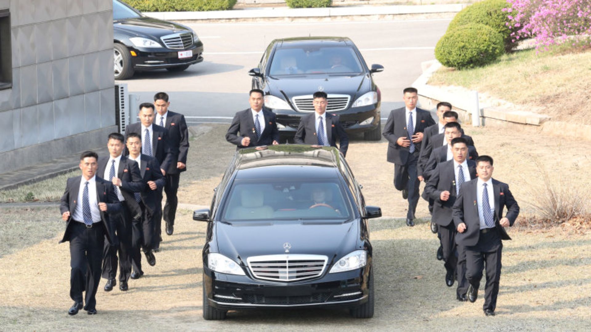 Security personnel accompany a vehicle transporting North Korean leader Kim Jong Un at the truce village of Panmunjom