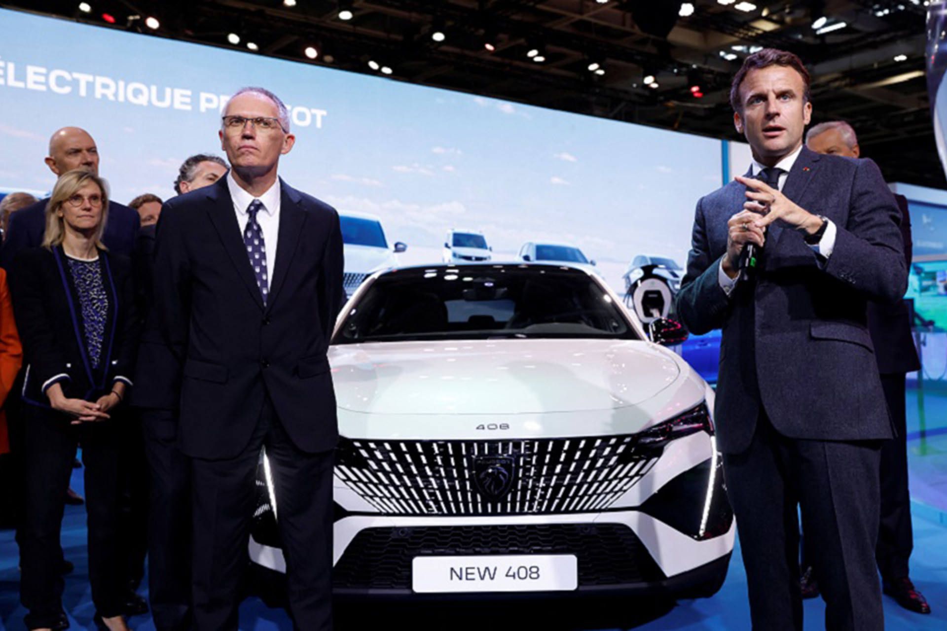 French President Emmanuel Macron speaks next to Carlos Tavares, Peugeot chairman and Stellantis chief executive, at the 2022 Paris Auto Show in France, October 17, 2022. REUTERS/Gonzalo Fuentes/Pool