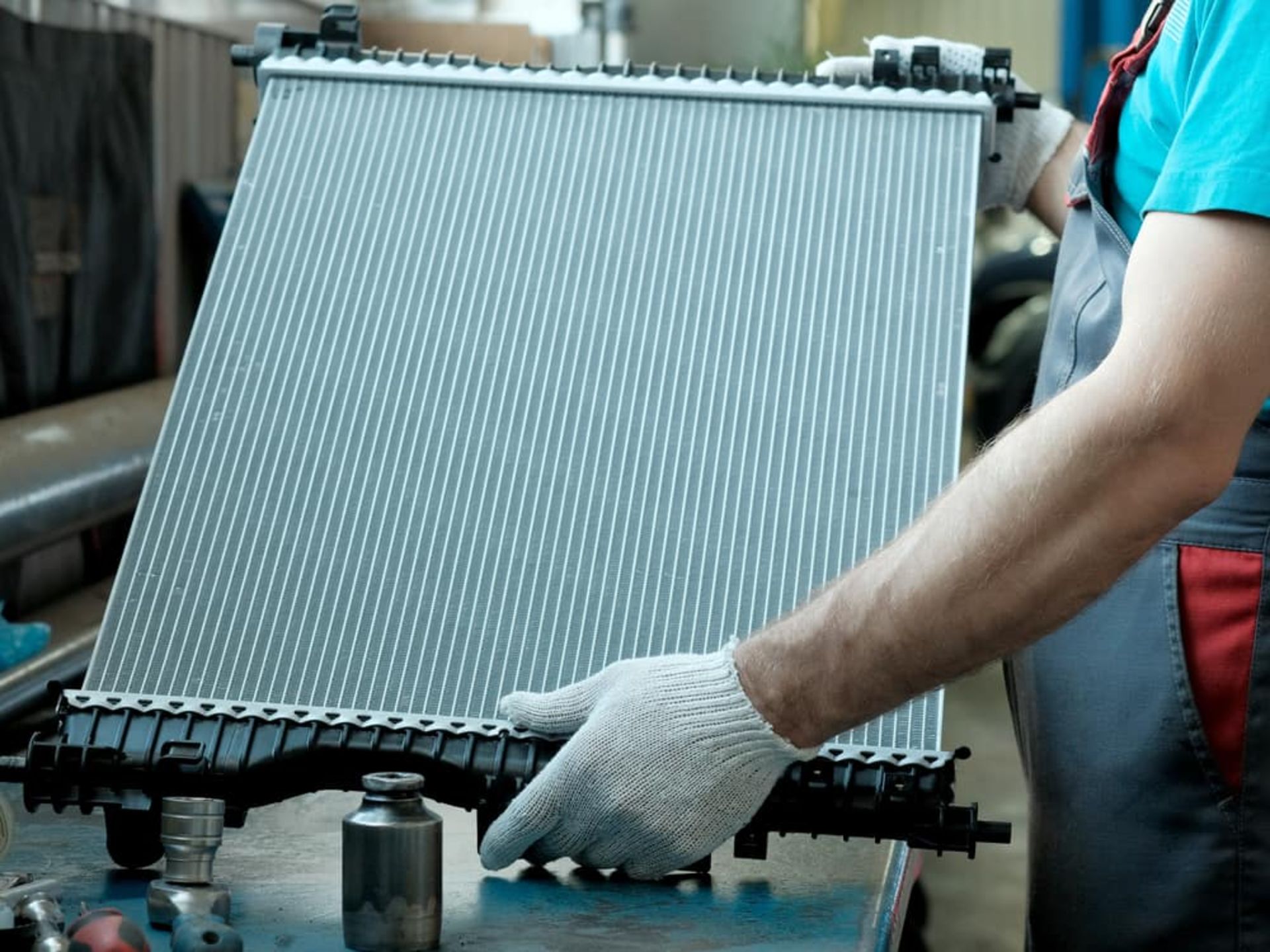 Mans-Gloved-Hands-Holding-a-New-Car-Radiator