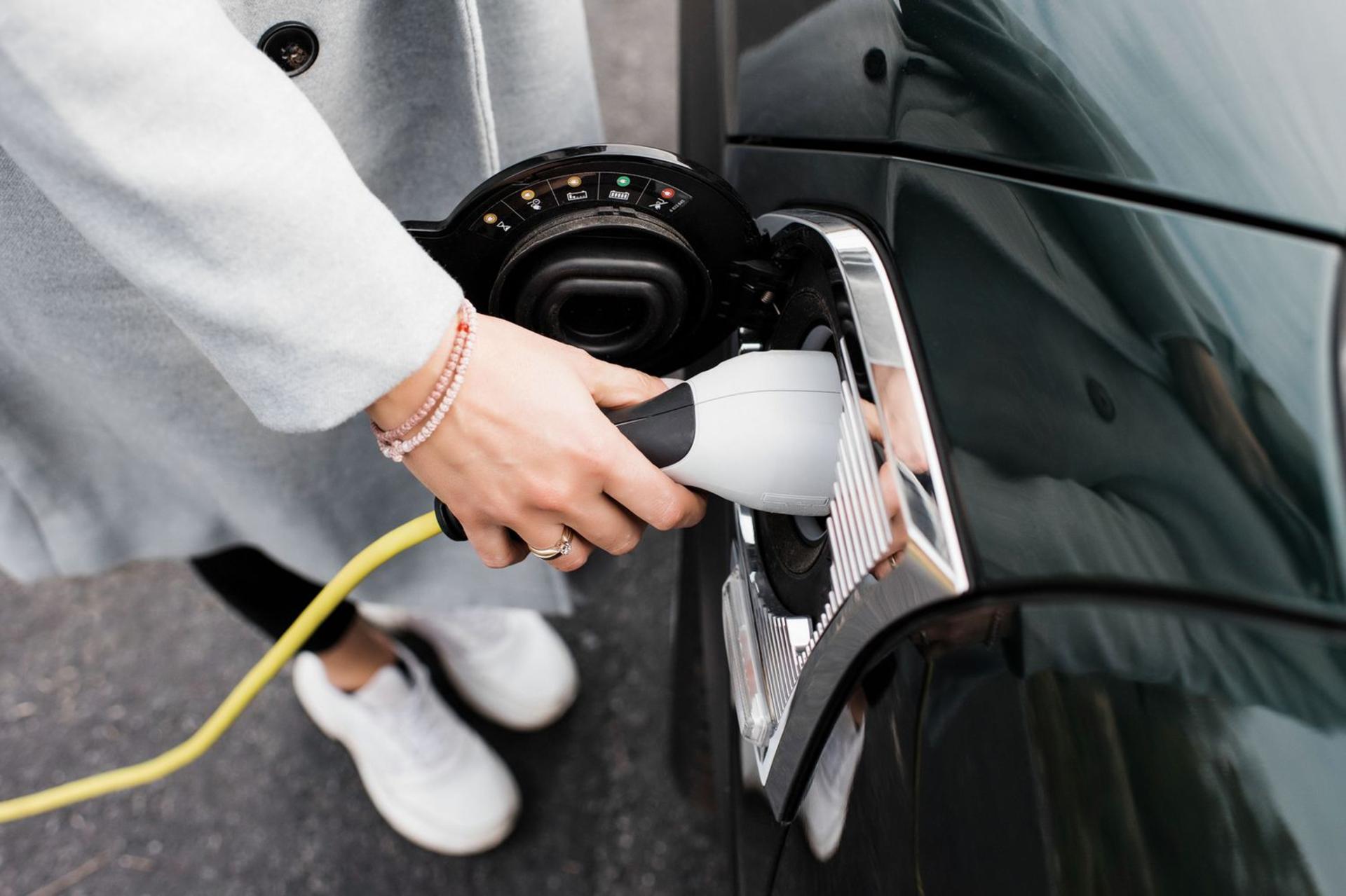 woman-s-hand-plugging-in-a-charging-lead-to-her-electric-car-1202288138-cc207d3c8d7b4308bfd716bcd895e23d
