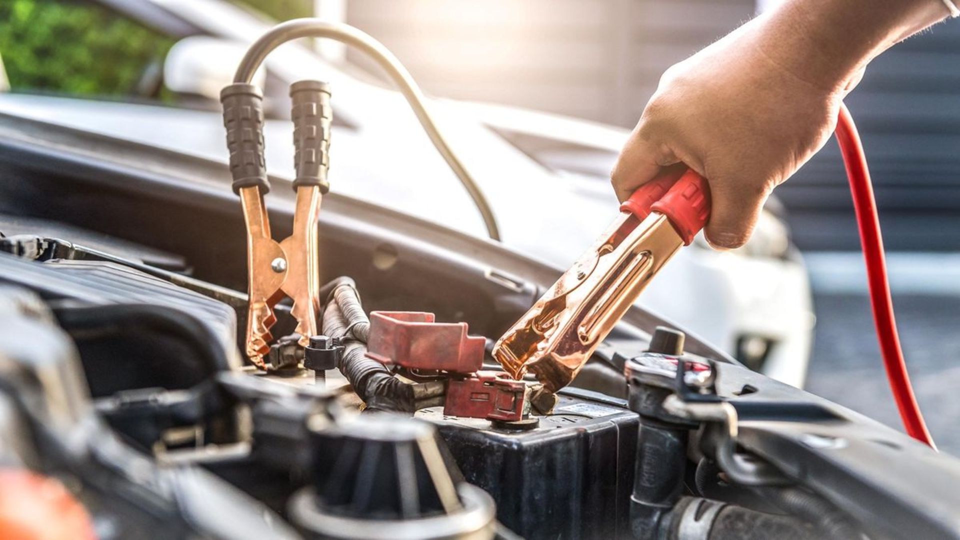 Close up of hand Charging car battery with electricity trough jumper cables