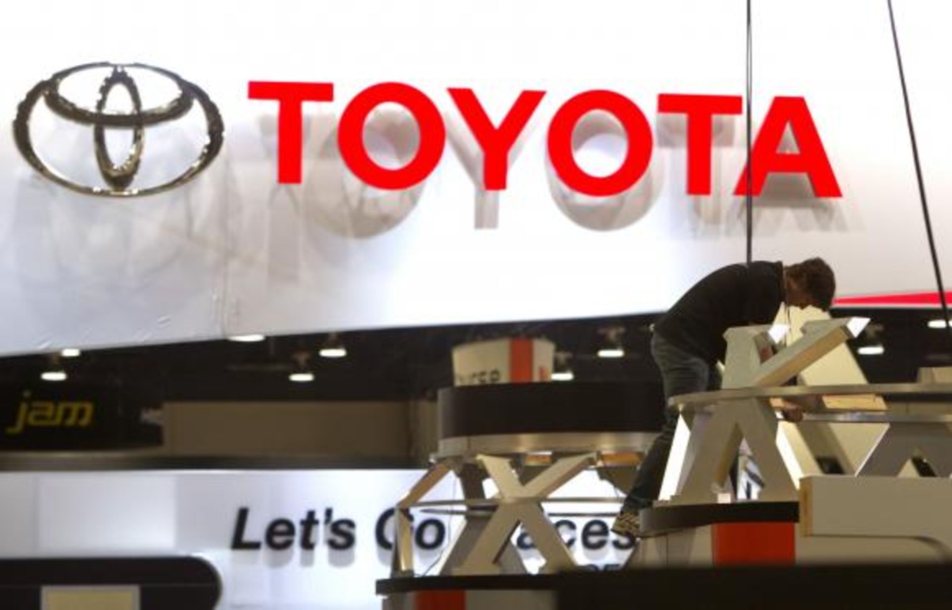 Worker sets up display near Toyota booth in preparation for the 2014 Consumer Electronics Show at the Las Vegas Convention Center in Las Vegas