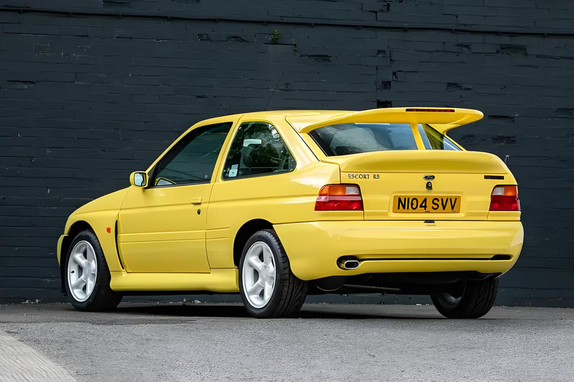 خودرو اسپرت فورد اسکورت آر اس (Ford Escort RS) زرد رنگ در مقابل دیوار سیاه