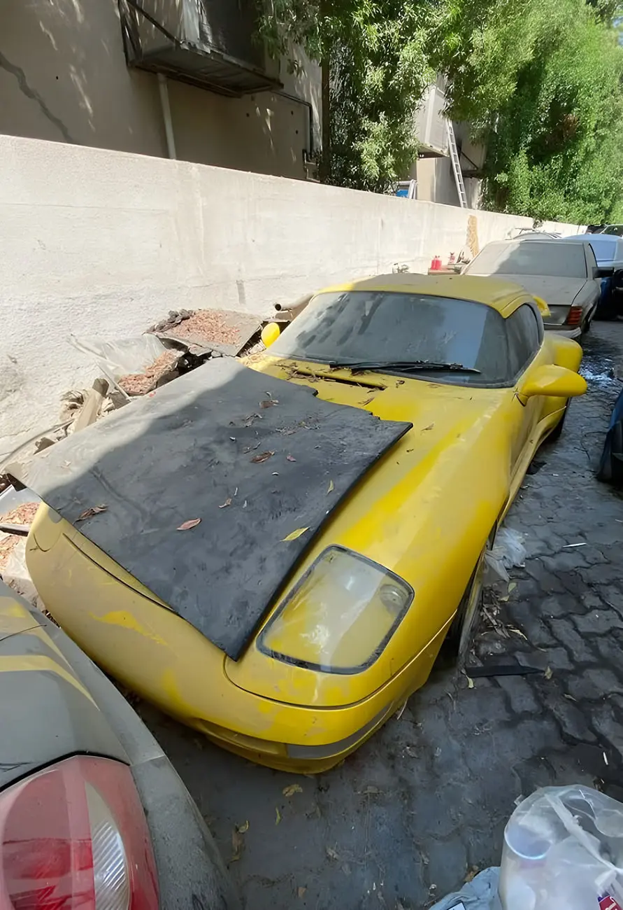 خودروی زرد رنگ پورشه (Porsche) 911 با بدنه کثیف و پوشیده شده